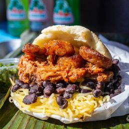 Chellas on Queen signature dishes Pernil ArepaChicken ArepaRoasted Pork Bowl